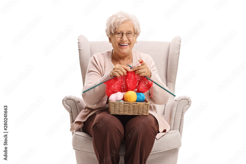 Canvas Prints Elderly woman in an armchair knitting and smiling at the camera