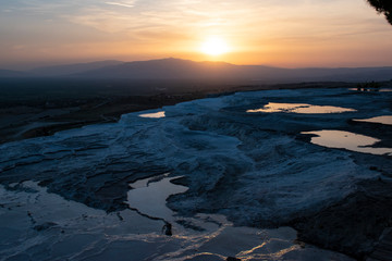Turkey, sunset on the travertine terraces at Pamukkale (Cotton Castle), natural site of sedimentary rock deposited by water from the hot springs, famous for a carbonate mineral left by flowing water