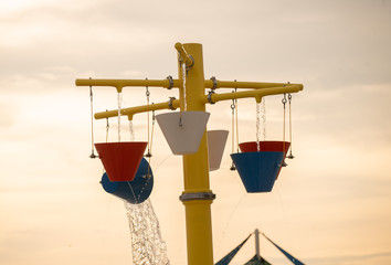 water buckets pour out at a water park giving relief on a hot summer day