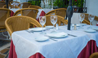 Sun terraces with empty glass glasses and table set to eat or have a snack in Marbella, Malaga, Spain
