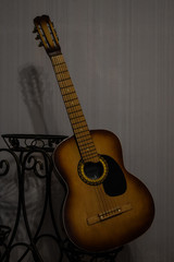 Obraz premium classic acoustic guitar propped in front of a white wall as background