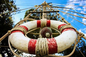 Lifebelt on the wooden mast - obrazy, fototapety, plakaty