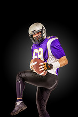 American football player in motion with the ball on a black background with a light line, copy space. The concept of the game is American football, movement. Black white background, copy space. sport