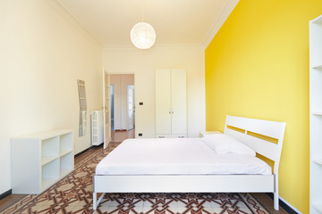 Renovated bedroom in apartment for rent with white and yellow walls