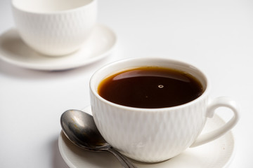 white cup for coffee with a spoon on a white background