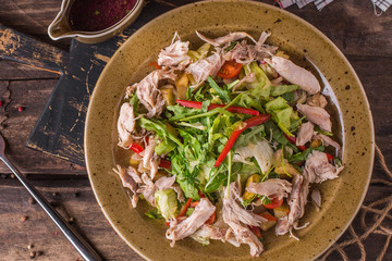 Sliced chicken with fresh herbs and peppers on a plate
