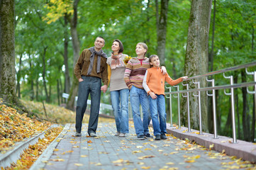 Family of four walking in autumn park