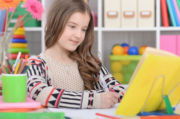 Portrait of cute little girl doing homework