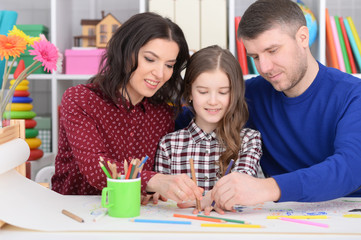 Portrait of parents and daughter doing homework