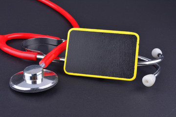 Stethoscope on black background with text. MEDICAL CONCEPT