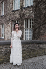 Wedding photo shooting. Bride walking in Brugge. Stand on bridge and hug.