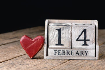 Wooden calendar show of February 14. Red heart.