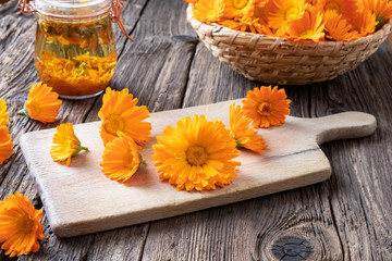 Calendula flowers on a cutting board with tincture