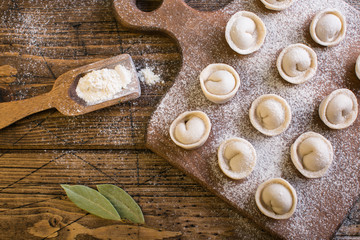 Raw Russian traditional dumplings on wooden background