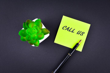 Green sticky note with pen with text CALL US