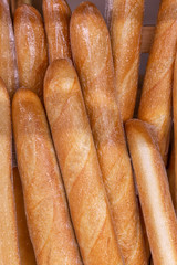 Fresh baguettes in the package on the counter in the store. Close-up. Vertical.