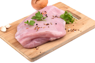 Raw turkey fillet with spices on a wooden cutting board over white background.