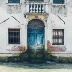 Venice Grand Canal (Canal Grande). Beautiful ancient architecture. Windows and blue  door on white wall. Door and wall with the mold.