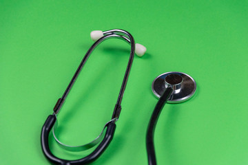 medical stethoscope on green background. helthcare and cardiology background