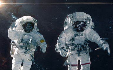 Two astronauts on background of nebulae and star clusters. Deep space landscape. Science fiction....