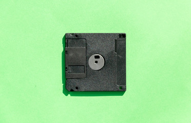 black floppy disk on green background. retro magnetic storage