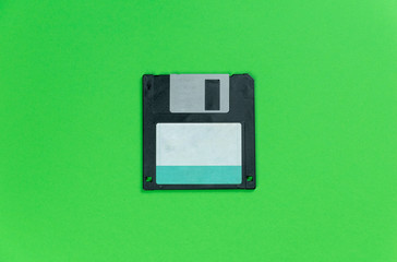 black floppy disk on green background. retro magnetic storage