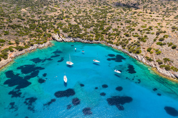 Aerial drone view of traditional Greek wooden boats floating on the crystal clear waters of the Aegean Sea (Crete)