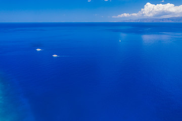 Obraz premium Aerial drone view of traditional Greek wooden boats floating on the crystal clear waters of the Aegean Sea (Crete)