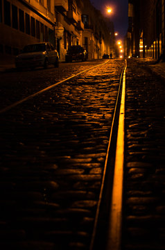 Dark street at night with abandoned train rails
