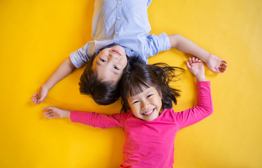 Portrait of young happy little asian boy girl in on yellow background. Education for preschool...