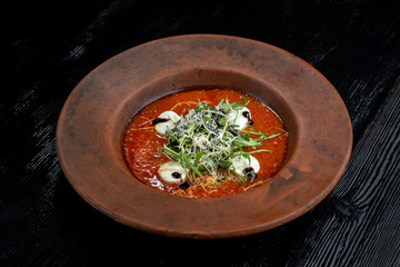 Tomato soup with arugula and grated cheese.