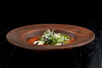 Tomato soup with arugula and grated cheese.