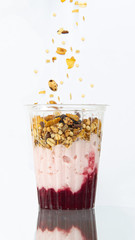 Yogur con cereales y granola en vaso de plastico transparente