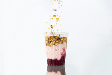 Yogur con cereales y granola en vaso de plastico transparente