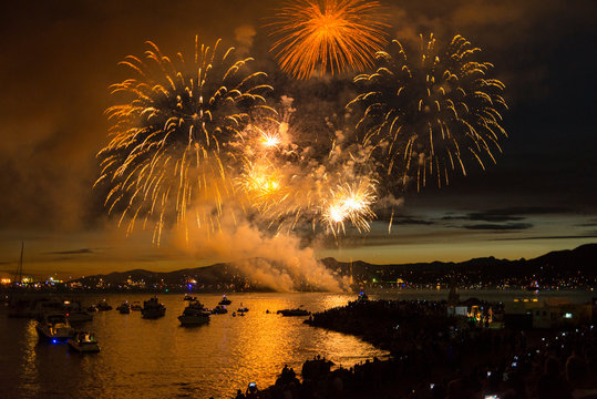 Panoramic view of fireworks exploding over bay