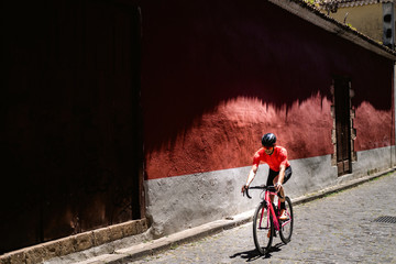 Cyclist riding bicycle on cobble street