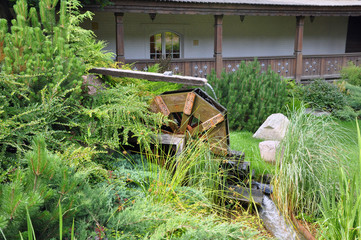 Driving mill wheel with falling water in the garden.