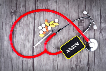 Pills, Syringe and Stethoscope with text Addiction