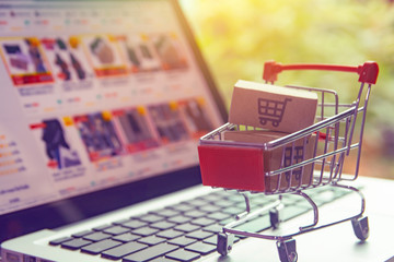 Shopping online concept - Parcel or Paper cartons with a shopping cart logo in a trolley on a...