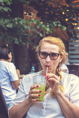 Middle age pretty woman with cocktail at outdoor restaurant.