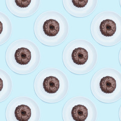 Chocolate donut pattern on a plate on a blue background.