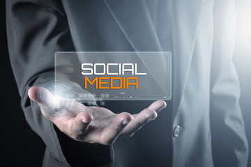 Hand holding transparent screen with text SOCIAL MEDIA