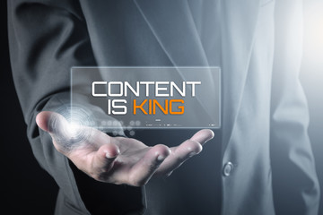 Hand holding transparent screen with text CONTENT IS KING