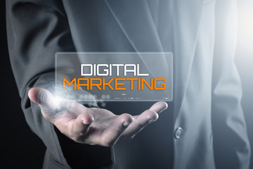 Hand holding transparent screen with text DIGITAL MARKETING