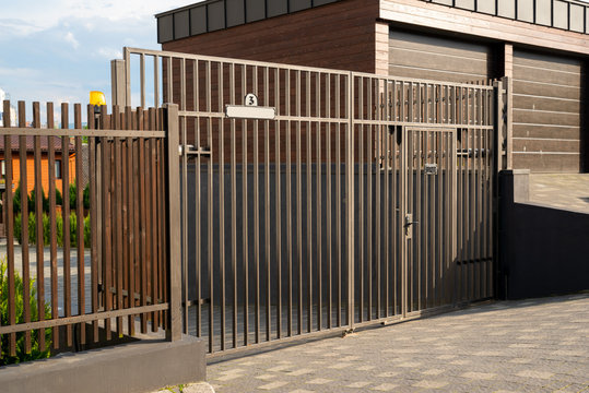 metal gate with automatic opening on the road  to the courtyard next to the garages