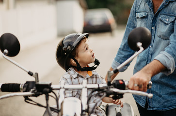 Father teaching his son to ride motorcycle