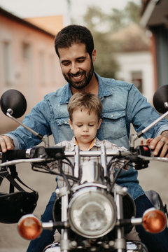 A happy father with his son drives a motorcycle
