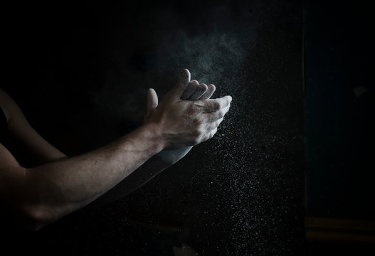 Man holding his hands together rubbing chalk for climbing