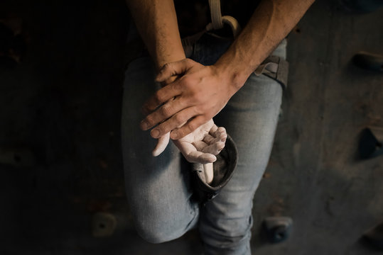 A sky view of man's hands whilst he is chalking getting ready to climb
