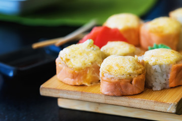 Hot rolls on a wooden stand with ginger and wasabi closeup